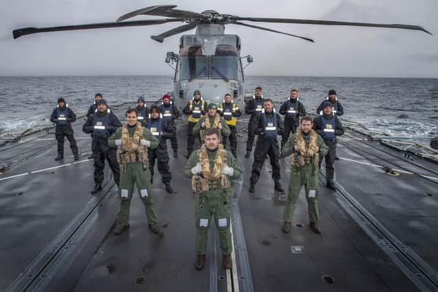 Pictured: 814 Naval Air Squadron have a group photo taken on the flight deck of HMS Kent.