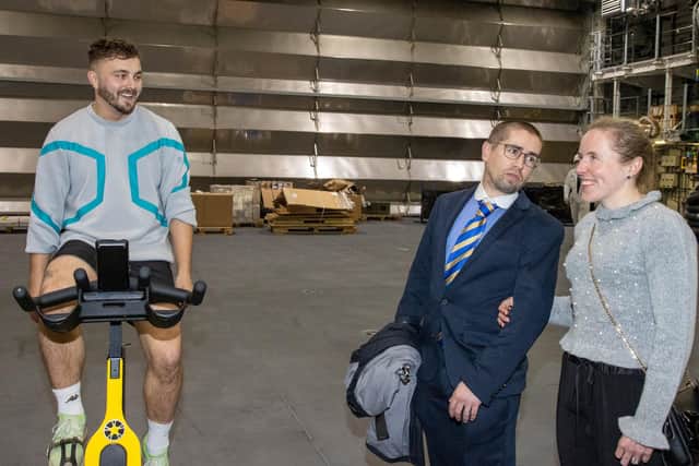 Paralympic cyclist gold medallists Neil Fachie and his wife Lora, speak with a sailor inside the hangar on HMS Prince of Wales. Photo: Alex Shute