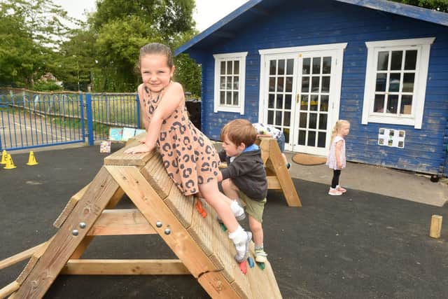 Winnie Johnson (three) and Harrison Hill (three) on the new climbing wall. Picture: Sarah Standing (240622-863)