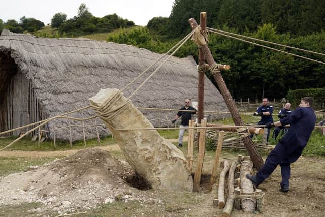 Crew members from HMS Queen Elizabeth and volunteers help raise a 3.5 tonne standing stone, using only traditional methods, at Butser Ancient Farm