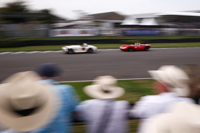 Racegoers watch as classic cars take part in a race during the opening day of Goodwood Revival at the Goodwood Motor Circuit in Chichester on September 8, 2023. The only historic motor race meeting to be staged entirely in a period theme, Goodwood Revival is an immersive celebration of iconic cars and fashion. (Photo by HENRY NICHOLLS / AFP) (Photo by HENRY NICHOLLS/AFP via Getty Images)