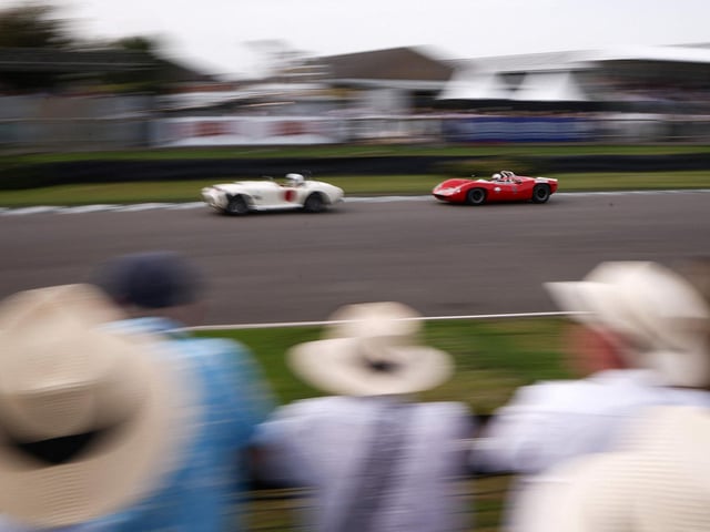 Racegoers watch as classic cars take part in a race during the opening day of Goodwood Revival at the Goodwood Motor Circuit in Chichester on September 8, 2023. The only historic motor race meeting to be staged entirely in a period theme, Goodwood Revival is an immersive celebration of iconic cars and fashion. (Photo by HENRY NICHOLLS / AFP) (Photo by HENRY NICHOLLS/AFP via Getty Images)