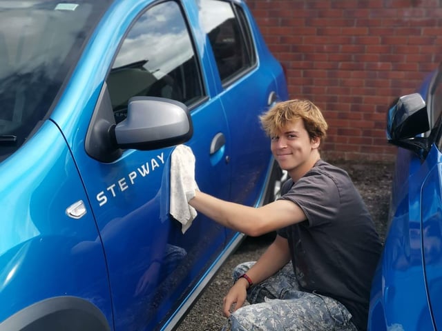 18 year old Caleb raising funds at a Car Wash fundraiser for the trip