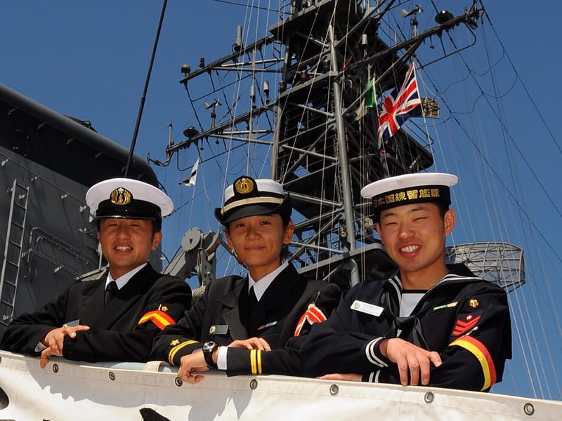 Welcome to our Japanese warship. (left to right)  PO3 Gunner Takafumi Harusaki, with  Assistant Engineer Officer Lt.JG Kaori Sei, and Leading Seaman and Operation Specialist Ippei Takeuchi from the JS TV Kashima , one of three Japanese ships from the Japan Maritime Self Defense Force (JMSDF). 24th August 2008. Picture: Malcolm Wells 083132-6961