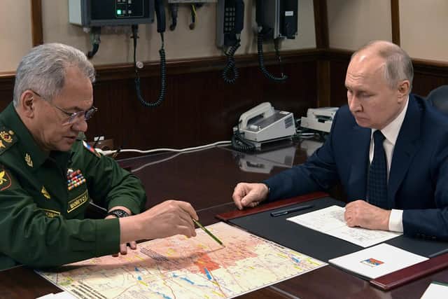 Photo distributed by Russian state agency Sputnik, Russia's President Vladimir Putin (R) attends a meeting with Russia's Defence Minister Sergei Shoigu (L) following a flag-raising ceremony on the frigate "Admiral Golovko" at the Severnaya Verf shipyard in Saint Petersburg, on December 25, 2023. The two reportedly spoke following the attack on a Russian landing ship in Crimea. Picture: ALEXEY DANICHEV/POOL/AFP via Getty Images.