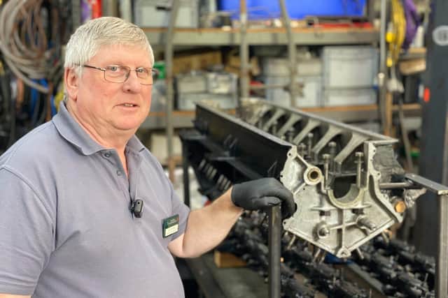 Senior Engineer Ian Stanfield with rear engine crankcase in workshop