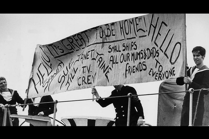 Sailors aboard HMS Intrepid unfurl their own special banner from the flight deck.1982