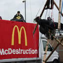 Image issued by Animal Rebellion showing Animal Rebellion protesters suspended from a bamboo structure and on top of a van, being monitored by police officers, outside a McDonalds distribution site in Basingstoke, which is being blockaded to stop lorries from leaving the depot. Picture: Andrea Domeniconi/PA Wire
