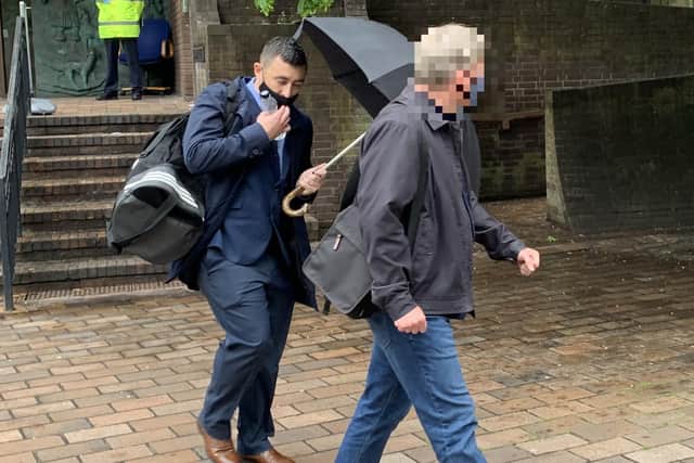 Former PCSO Joshua Fitzjohn leaves Portsmouth Crown Court holding an umbrella having been sentenced for coercive control of his wife.