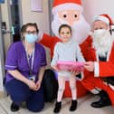 Sophia Ramalho, 5 receives a gift from Father Christmas (Dave Gosling) with Zoe Parton, play specialist at the children's emergency department.

Picture: Keith Woodland (181221-0)