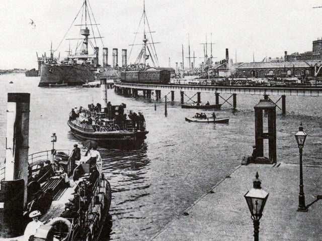 A view of the dockyard about 1908 with Gosport ferries in the foreground. The railway line opened in 1876. It was built as part of the harbour extension across the foreshore of Watering Island. The jetty here was constructed in 1860 and was especially suitable for troopships