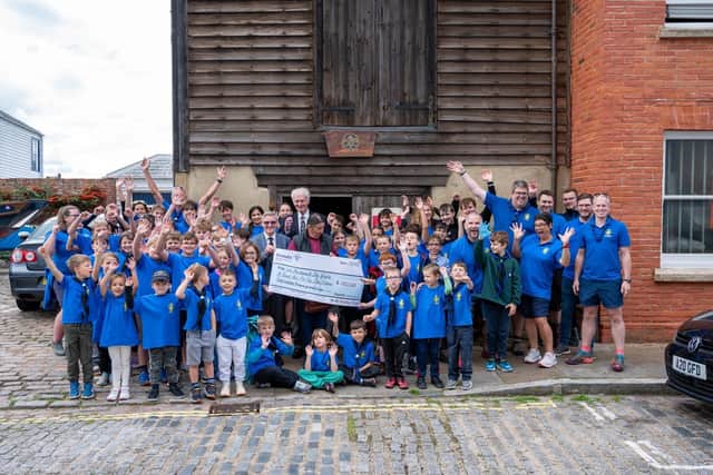 Jubilant Sea Scouts receiving £100k cheque in front of their Scout Hut
