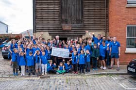 Jubilant Sea Scouts receiving £100k cheque in front of their Scout Hut