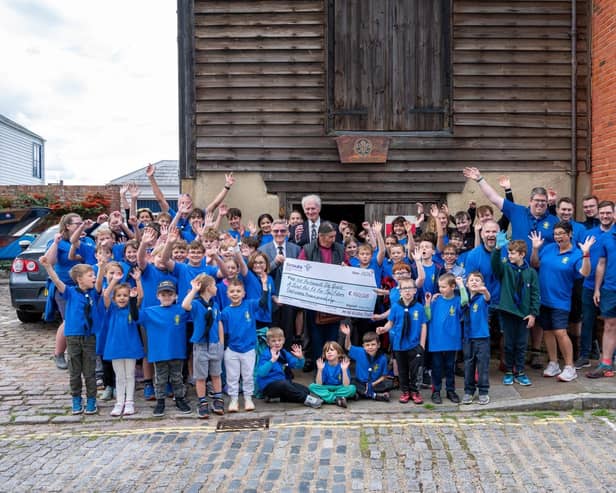 Jubilant Sea Scouts receiving £100k cheque in front of their Scout Hut