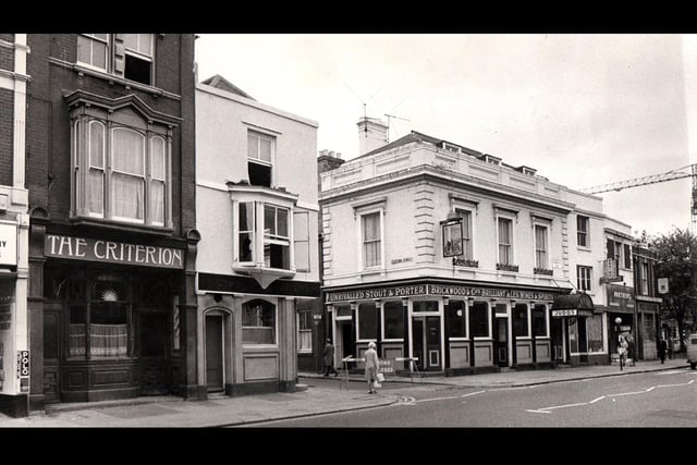 Station street 1973. It is  December 1973 and we have  four places to have a drink within fifty yards.To the left is the Criterion, then the Claremont Hotel. Crossing Station Street we have Judds Railway Hotel and then a restaurant, a fancy goods shop and another pub, the Lennox Arms.To the left of the Criterion is a tobacconist and then another pub, the  Albany.The crane would be working on the beginnings of the new civic offices in Guildhall Square.The junction of Station Street and Commercial Road in December 1973.