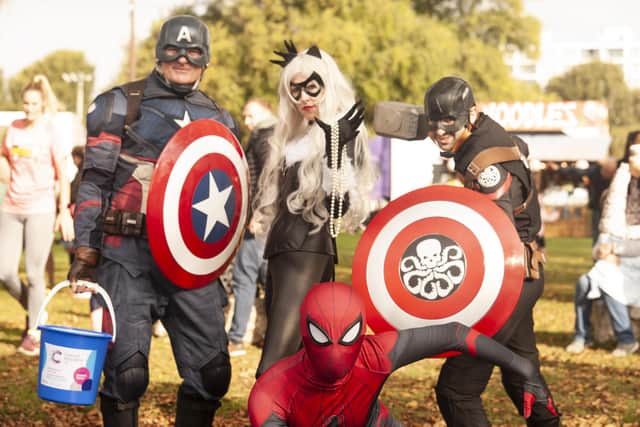 Superheroes Captain America and Spider-Man surround Cat Woman during the Great South Run 5k on Saturday, Photo: David Tiller