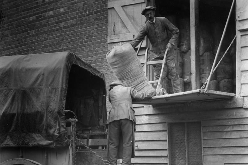 Sacks of grain change hands at the Old Water Mill in Winchester circa 1935:   (Photo by Herbert Felton/Herbert Felton/Getty Images)