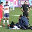 Godfrey Poku receives treatment for his knee injury prior to coming off during the first half of the FA Trophy tie against Notts County. Photo by Dave Haines