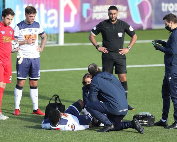 Godfrey Poku receives treatment for his knee injury prior to coming off during the first half of the FA Trophy tie against Notts County. Photo by Dave Haines