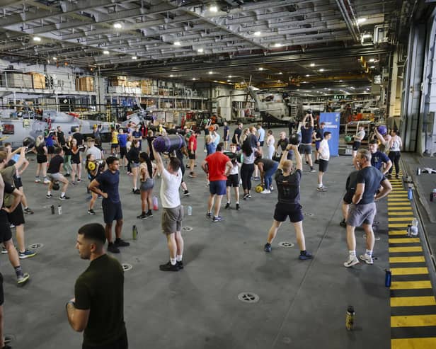 HMS Queen Elizabeth's ship's company take part in circuits in the hangar. Picture: LPhot Belinda Alker.