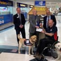 Allen Parton from Hounds for Heroes and his assistance dogs accepting the donation from The Rotary Club of Fareham.
