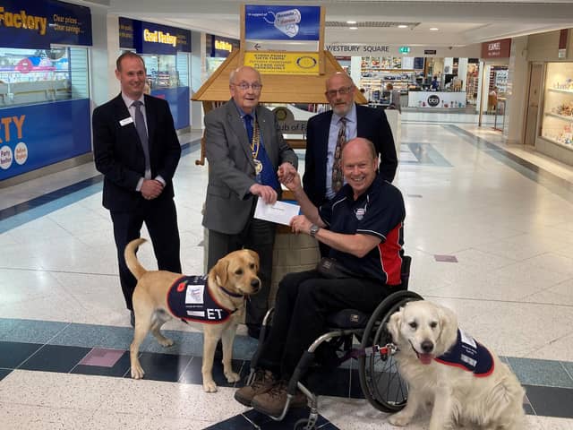 Allen Parton from Hounds for Heroes and his assistance dogs accepting the donation from The Rotary Club of Fareham.