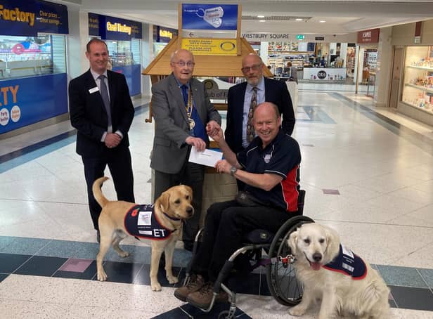 Allen Parton from Hounds for Heroes and his assistance dogs accepting the donation from The Rotary Club of Fareham.
