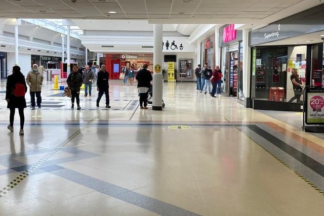 Shoppers wait at the entrance to HMV in the centre.