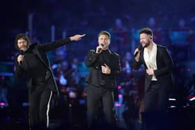 Howard Donald and Gary Barlow of Take That, perform with Callum Scott (right) on stage during the Coronation Concert