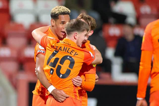 Goalscorer Haji Mnoga is hugged by his Pompey born-and-bred team-mates Alfie Stanley and Charlie Bell. Picture: Nigel Keene/ProSportsImages