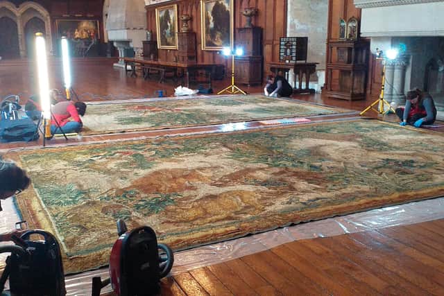 The Arundel Castle Gobelin tapestries being vacuumed gently, prior to rolling and transporting to Belgium.