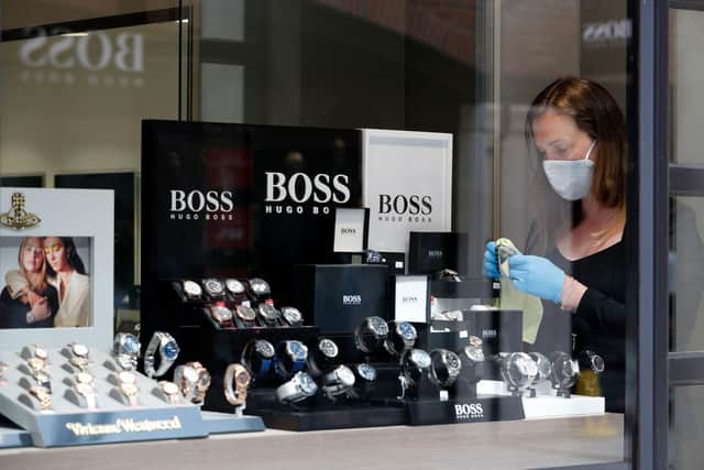 A retail worker wearing personal protective equipment as a precautionary measure against Covid-19, at Gunwharf Quays. Photo: Adrian Dennis/AFP via Getty Images