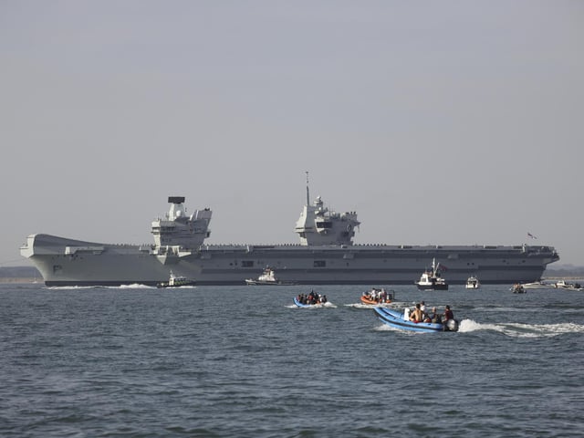 Pictured: HMS Queen Elizabeth enters the Solent off of Cowes and conducts a gun salute in front of the Royal Yacht Squadron.