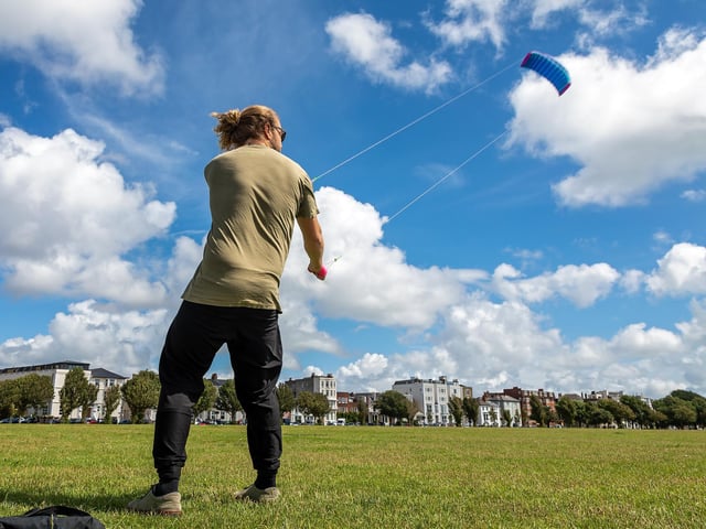 Josh Gent (27) doing his best to not take off at the Portsmouth Kite Festival. Picture: Mike Cooter (070821)