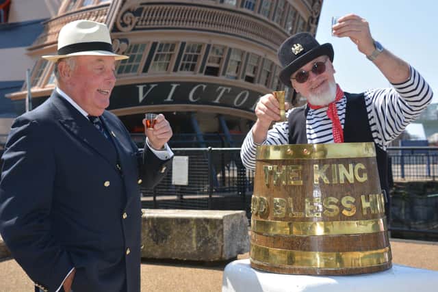 Vice Admiral John McAnally, national president of the Royal Naval Association (left) at Portsmouth Historic Dockyard toasts a tot of rum to mark the 50th anniversary of Black Tot Day - the day the Royal Navy stopped issuing sailors their daily rum ration, with Tom Coleman of the 'Andsome Cabin Boys sea shanty band. Photo: PA