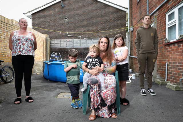 Residents Jade Jones (seated) and her children, Freddi, one, Michey, five, and Rosie, eight, with Rebecca Powell, left, and Harry Neal, 16, are unhappy with the removal of a trampoline in their communal area by Portsmouth City Council, at their block in Tangley Walk, Westleigh
Picture: Chris Moorhouse (jpns 120821-02)