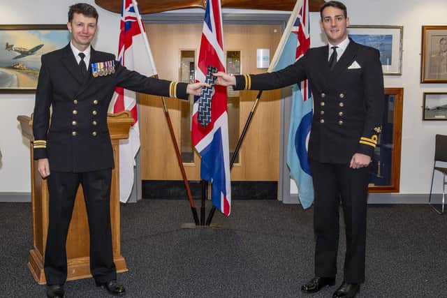 Lieutenant Commander Dave Bouyac, left, presents Lieutenant Lewis Phillips with his 'wings', after becoming the first to graduate using a new naval training jet.
