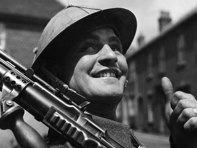 6th June 1944:  A British soldier, encamped in a small English village, gives the thumbs-up as he awaits his orders for D-Day.  (Photo by Fox Photos/Getty Images)