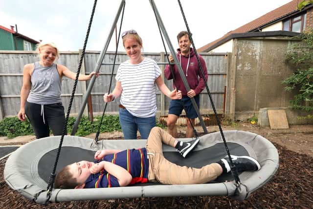 Archie Cleaver, 10, and his mother, Victoria Cleaver, have had their Paulsgrove garden made over by representatives from Propp, Glenhawk Finance, MT Finance, Together Finance and Helping Hands at Wellchild. They are pictured with the swing and the new garden behind them, with Sally Precious Ward, left, and Ben Larkin. Picture: Chris Moorhouse (jpns 040522-51).