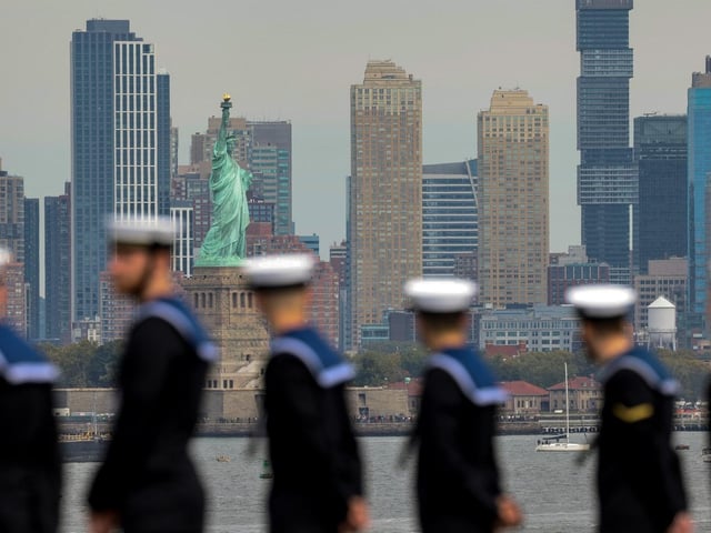 HMS Queen Elizabeth ship's company line the deck as the Royal Navy flagship sails into New York in September 2022 ahead of hosting the Atlantic Future Forum. The Nation's Flagship was followed up the Hudson by its escort, HMS Richmond.