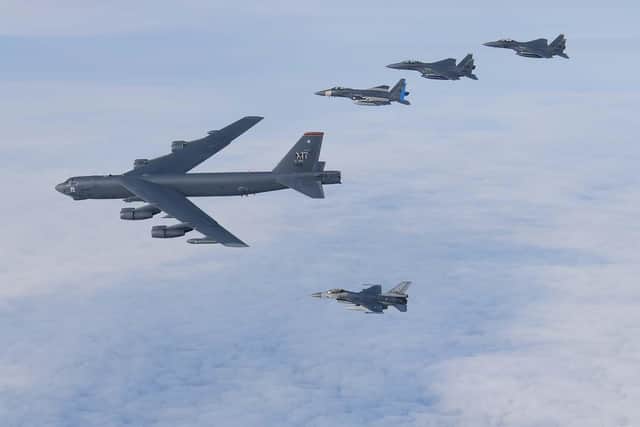 A B-52 bomber is joined by a number of fighter jets