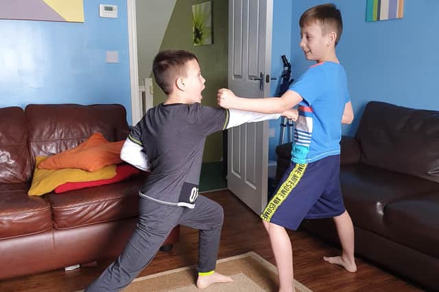 Mark Hague, 10, left, throws a punch at his brother Myles, nine, inside their living room in Cosham. Photo: Pauline Hague