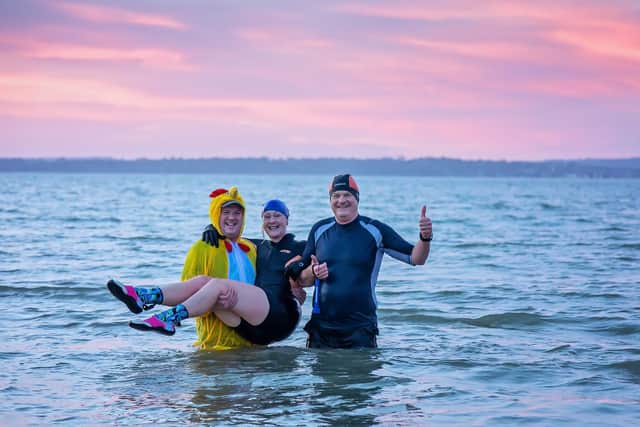Timothy Angel (48), Meryl Walker (57) and Jonnie Angel (56) from #Vitamin_Sea_Gosport during their dawn swim at Stokes Bay. Picture: Mike Cooter (010122)