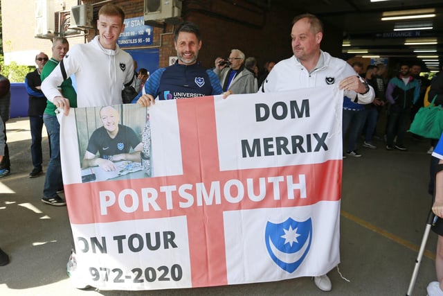 Pompey boss Danny Cowley and defender Hayden Carter poses with a flag with a fan.