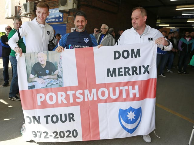 Pompey boss Danny Cowley and defender Hayden Carter poses with a flag with a fan.