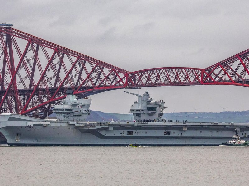 HMS Queen Elizabeth makes her way under the Forth Bridges as she prepares to dock at Rosyth dockyard for repairs, March 21 2024.