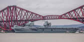 HMS Queen Elizabeth makes her way under the Forth Bridges. 