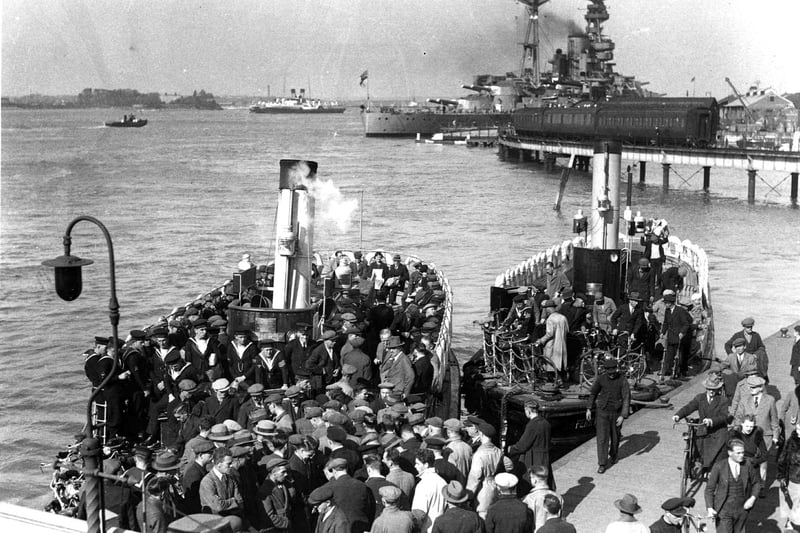 A packed Gosport ferry
In 1936 we see Dockyardmen, sailors and ordinary folk boarding and alighting two Gosport Ferries.
To the rear can be seen the railway viaduct that linked the harbour Station to the South Railway Jetty.
Tied up at the jetty is a pre-war battleship and to the left of her are two Isle of Wight paddle steamers. Picture; Courtesy of Sid Greeman.