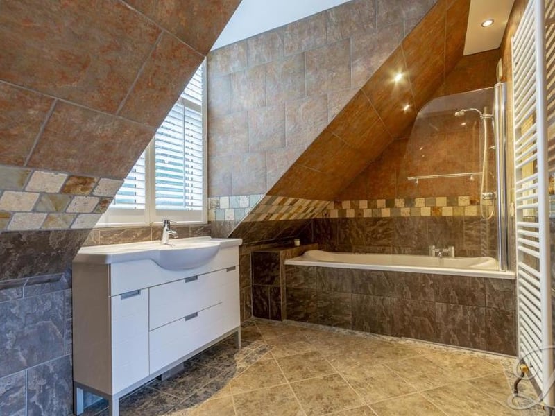 The en suite to the master bedroom is a stylish, unique space. It comes with shower over bath, low-flush WC, bidet, pedestal wash basin, central-heating radiator and opaque window with wooden plantation shutters.