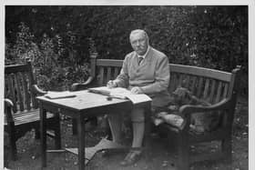 Portrait of Sir Arthur Conan Doyle sitting at a table in his garden, Bignell Wood, New Forest, 1927. (Photo by Fox Photos/Hulton Archive/Getty Images)